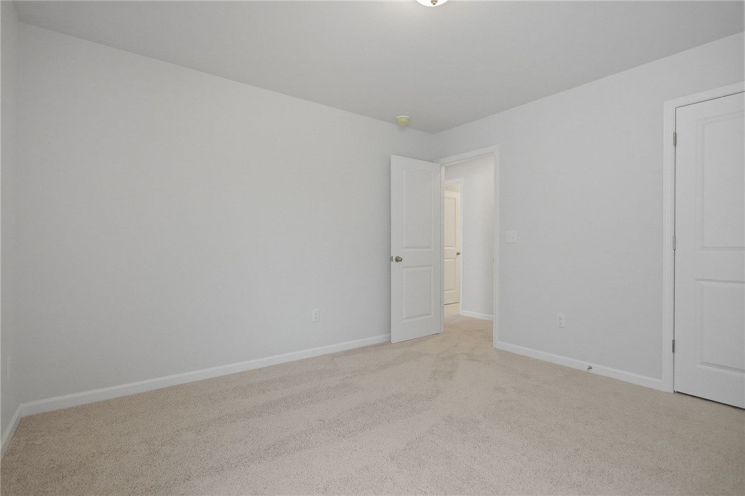 557 Hydrangea Street, Unit LOT 46 Seneca, SC 29678 - Photo 29 of 37 A spacious, naturally illuminated room featuring plush carpet flooring and pristine white walls, ready for personalized touches.