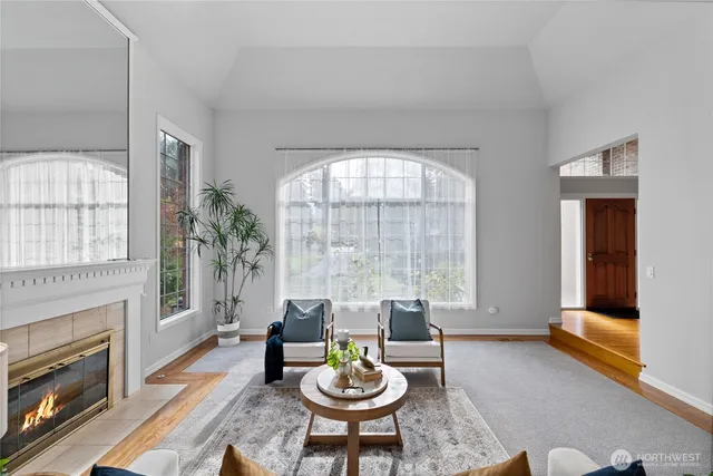 a living room with furniture a fireplace and a large window
