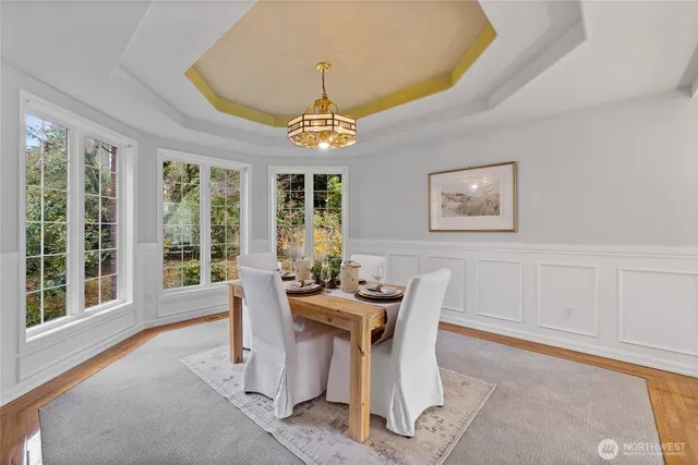 a dining room with furniture a chandelier and wooden floor
