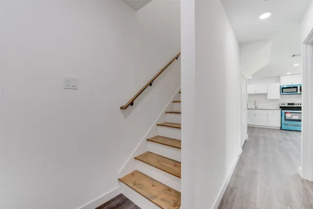 a view of a kitchen with wooden floor and stairs