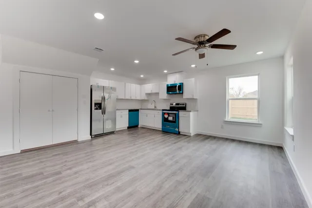 a view of an empty room with kitchen appliances and a window