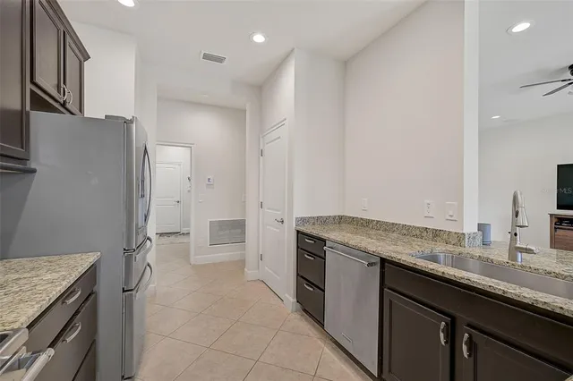 a kitchen with granite countertop a sink stove and refrigerator