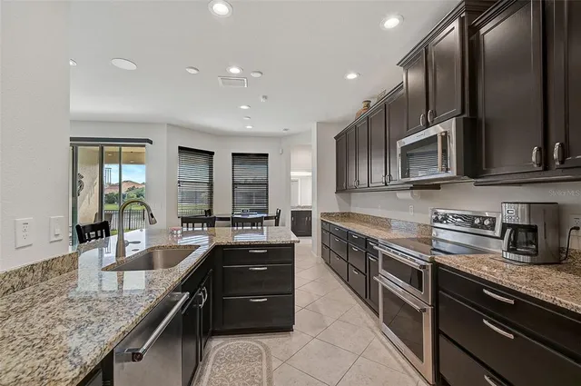 a large kitchen with granite countertop a sink and cabinets