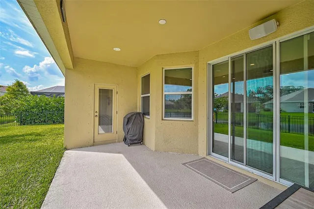 a view of a chair and table in backyard of the house