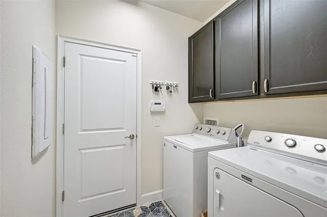 a view of washer and dryer with bathroom in the background