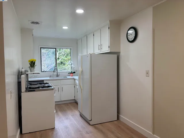 a kitchen with cabinets appliances and a window