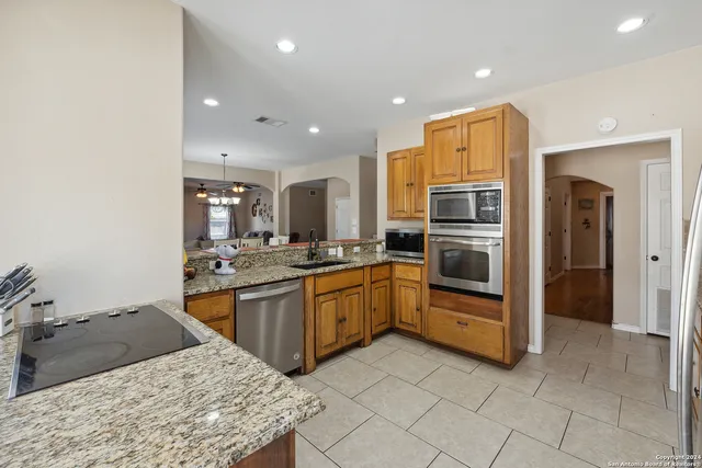 a kitchen with stainless steel appliances granite countertop a refrigerator and a sink