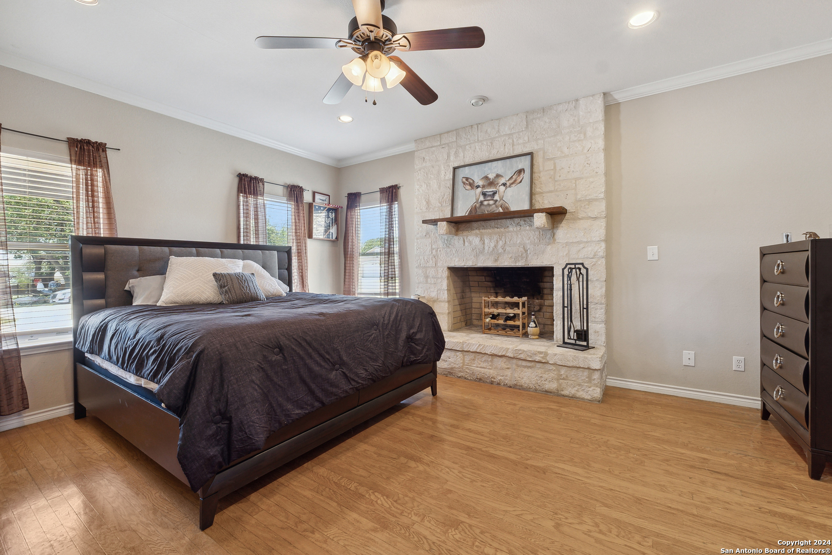 166 Desert Poppy Drive Bandera, TX 78003 - Photo 23 of 50 a spacious bedroom with a bed and a fireplace