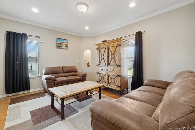 a living room with furniture a rug and a window