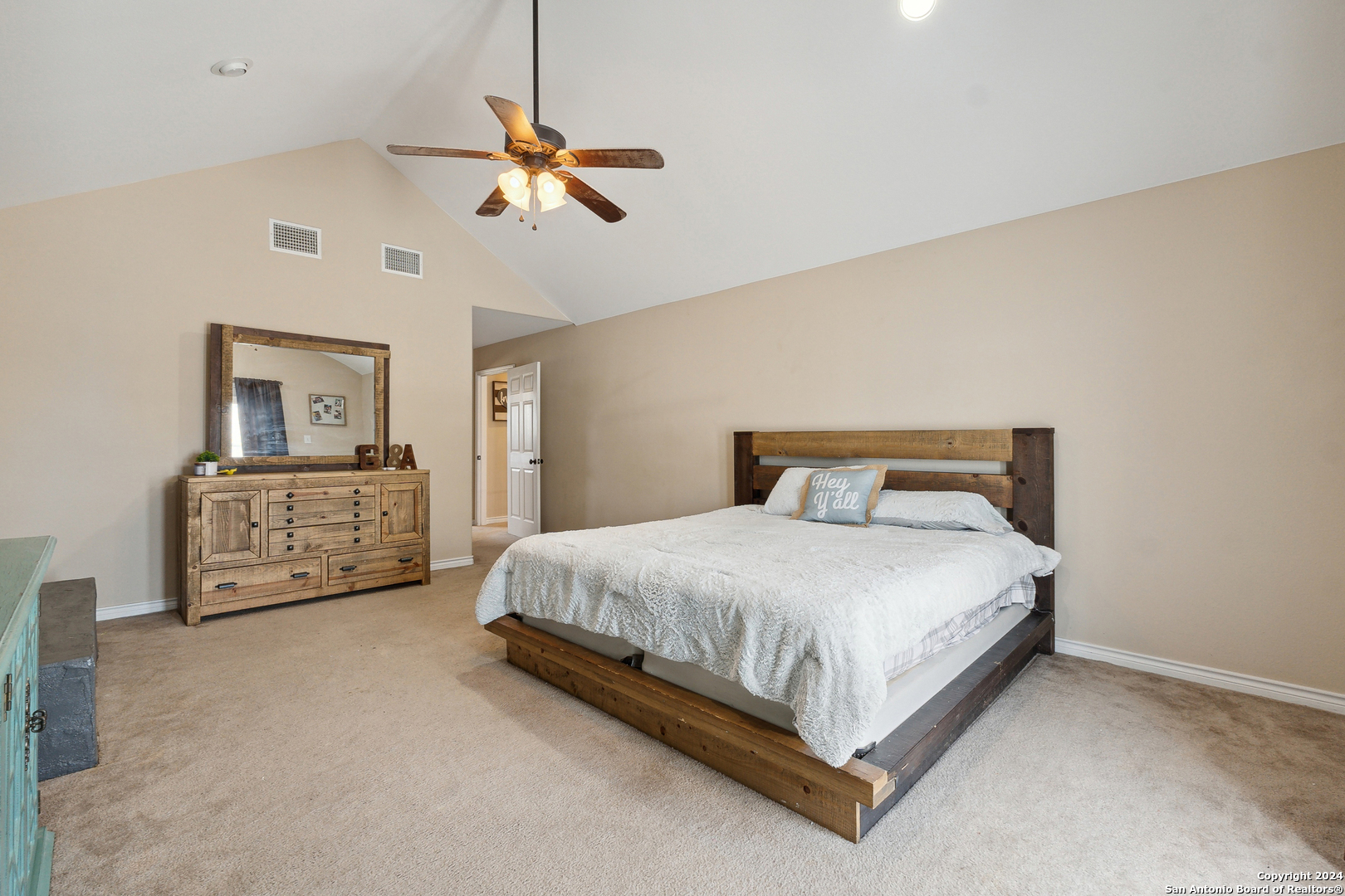 166 Desert Poppy Drive Bandera, TX 78003 - Photo 28 of 50 a spacious bedroom with a bed a couch and a chandelier