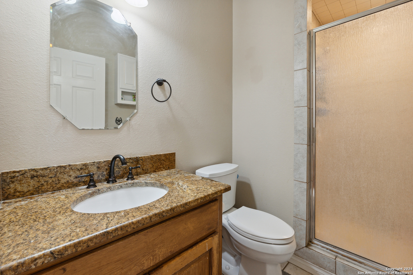 166 Desert Poppy Drive Bandera, TX 78003 - Photo 29 of 50 a bathroom with a granite countertop sink toilet and a mirror