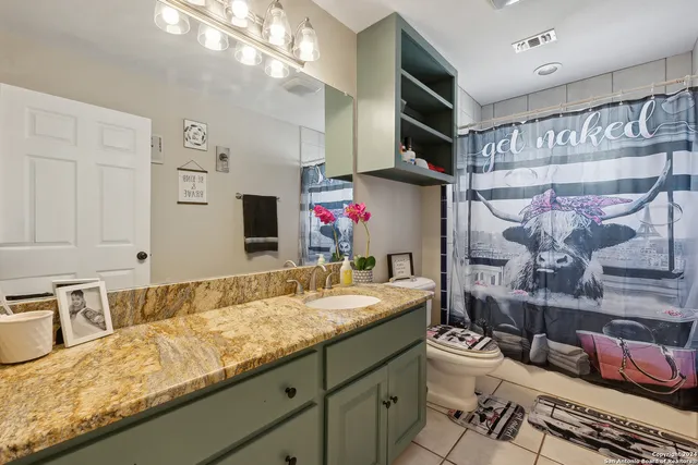 a bathroom with a granite countertop sink a large mirror and shower