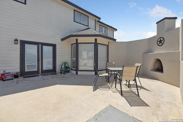 a view of a patio with table and chairs and potted plants