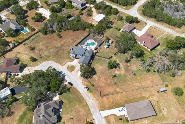 an aerial view of a house with a yard and lake