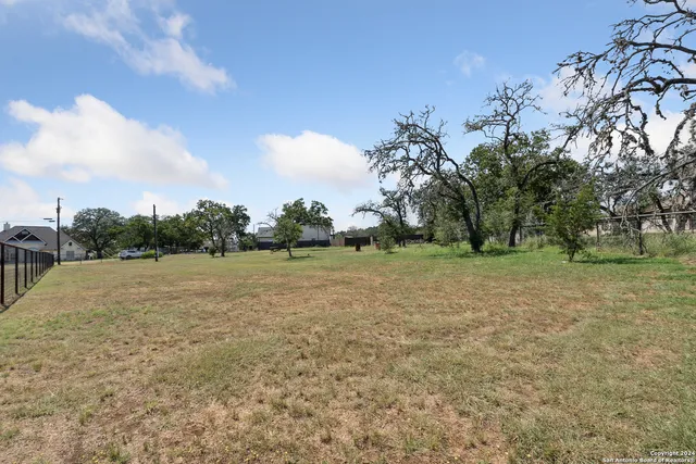 a view of dirt field with trees in background