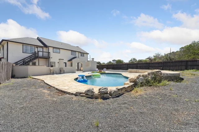 a swimming pool with outdoor seating and plants