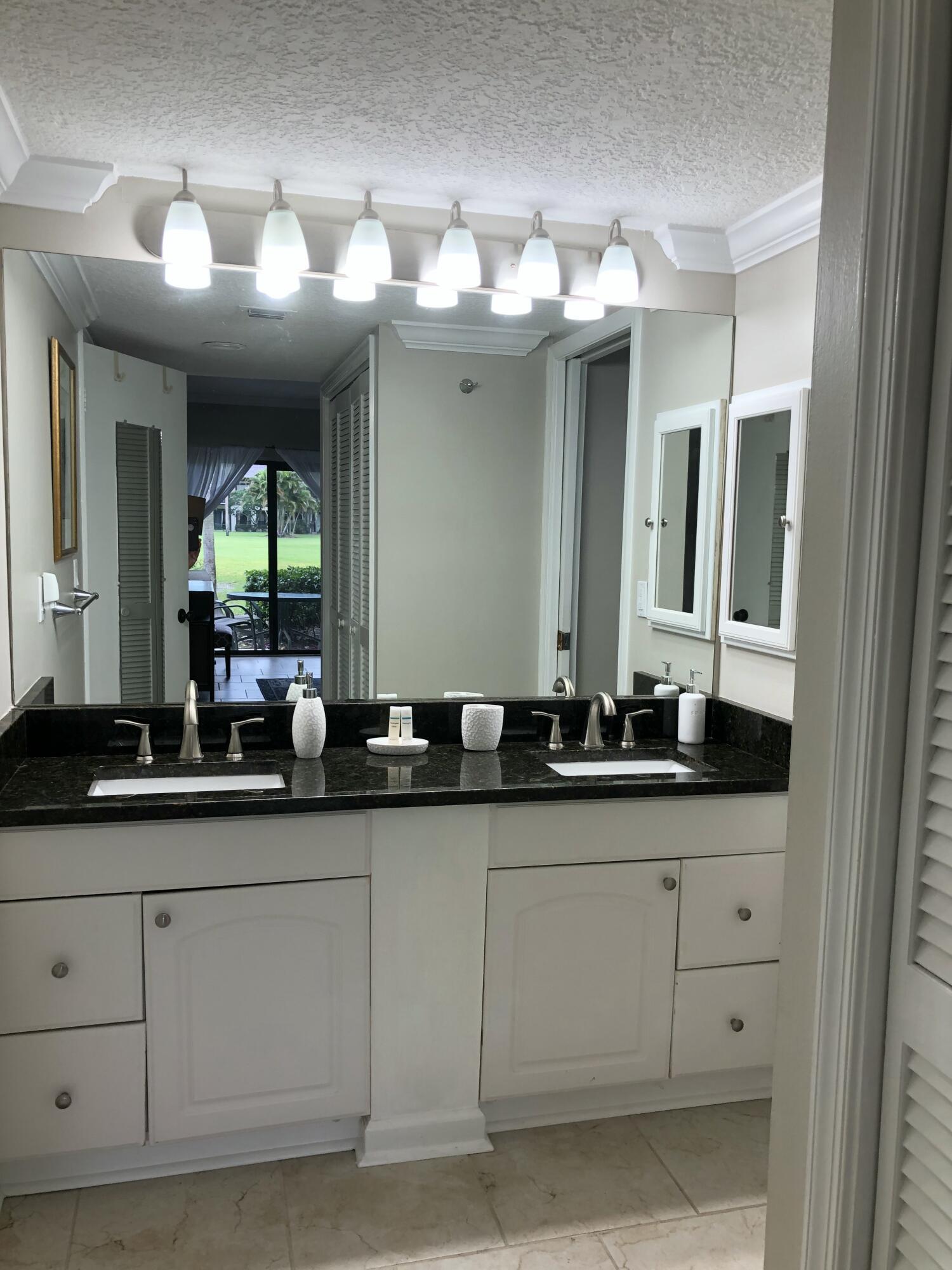 13334 Polo Club Road, Unit 218 Wellington, FL 33414 - Photo 9 of 13 a bathroom with a sink and a mirror