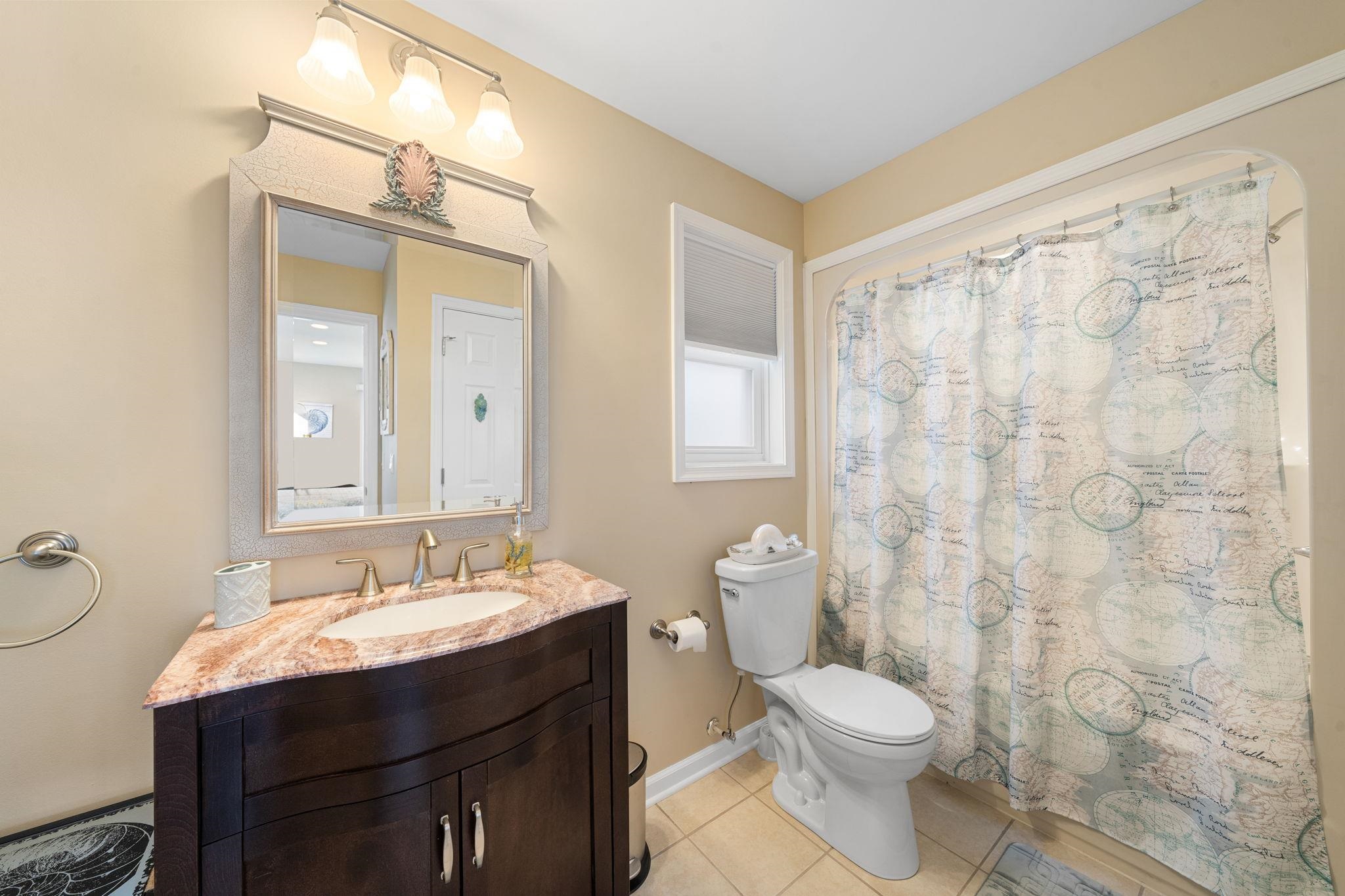 704 South Commonwealth Avenue Strathmere, NJ 08248 - Photo 20 of 50 a bathroom with a sink a toilet and shower curtain