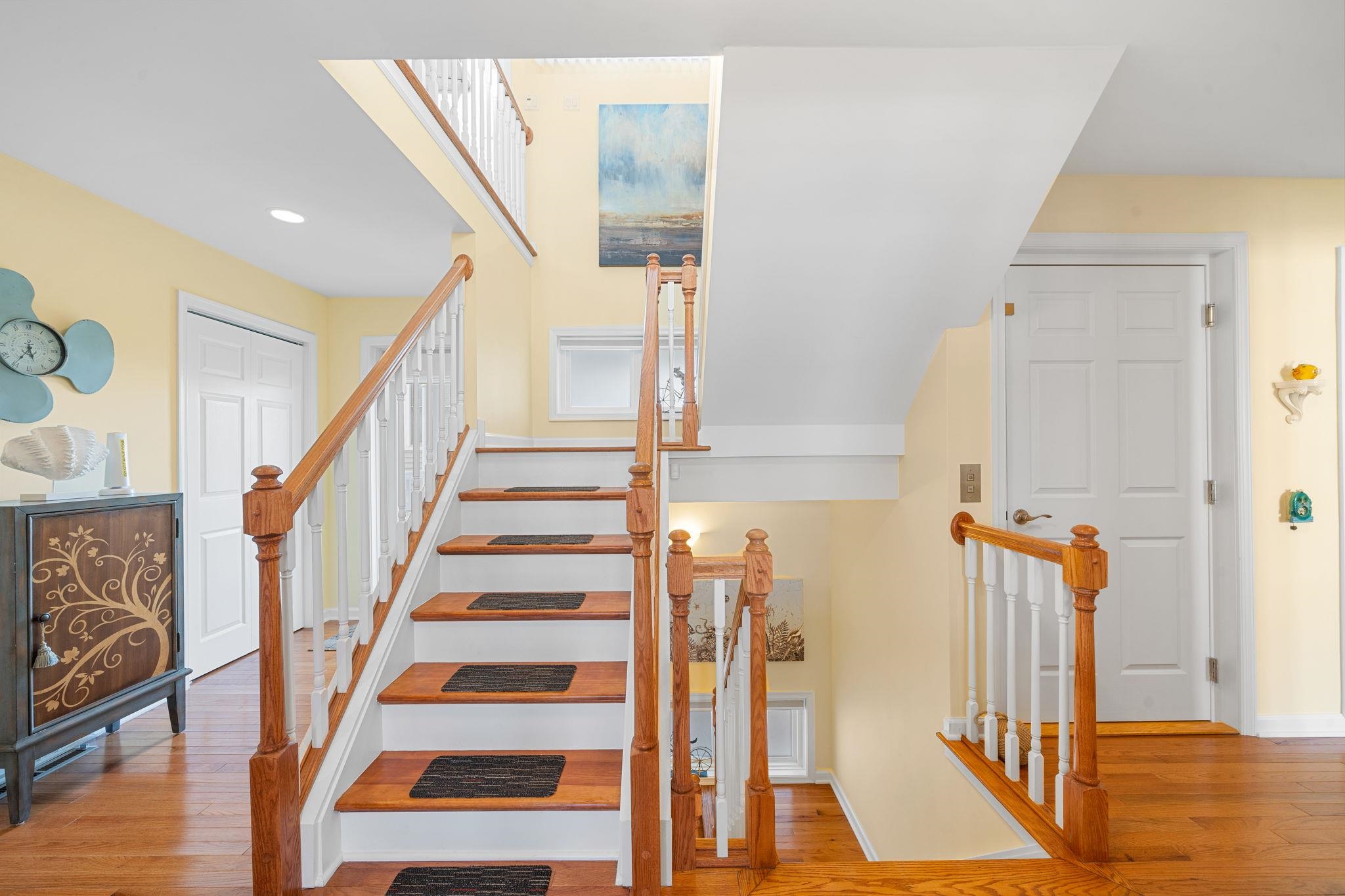 704 South Commonwealth Avenue Strathmere, NJ 08248 - Photo 21 of 50 a view of staircase with lots of frames on wall and wooden floor