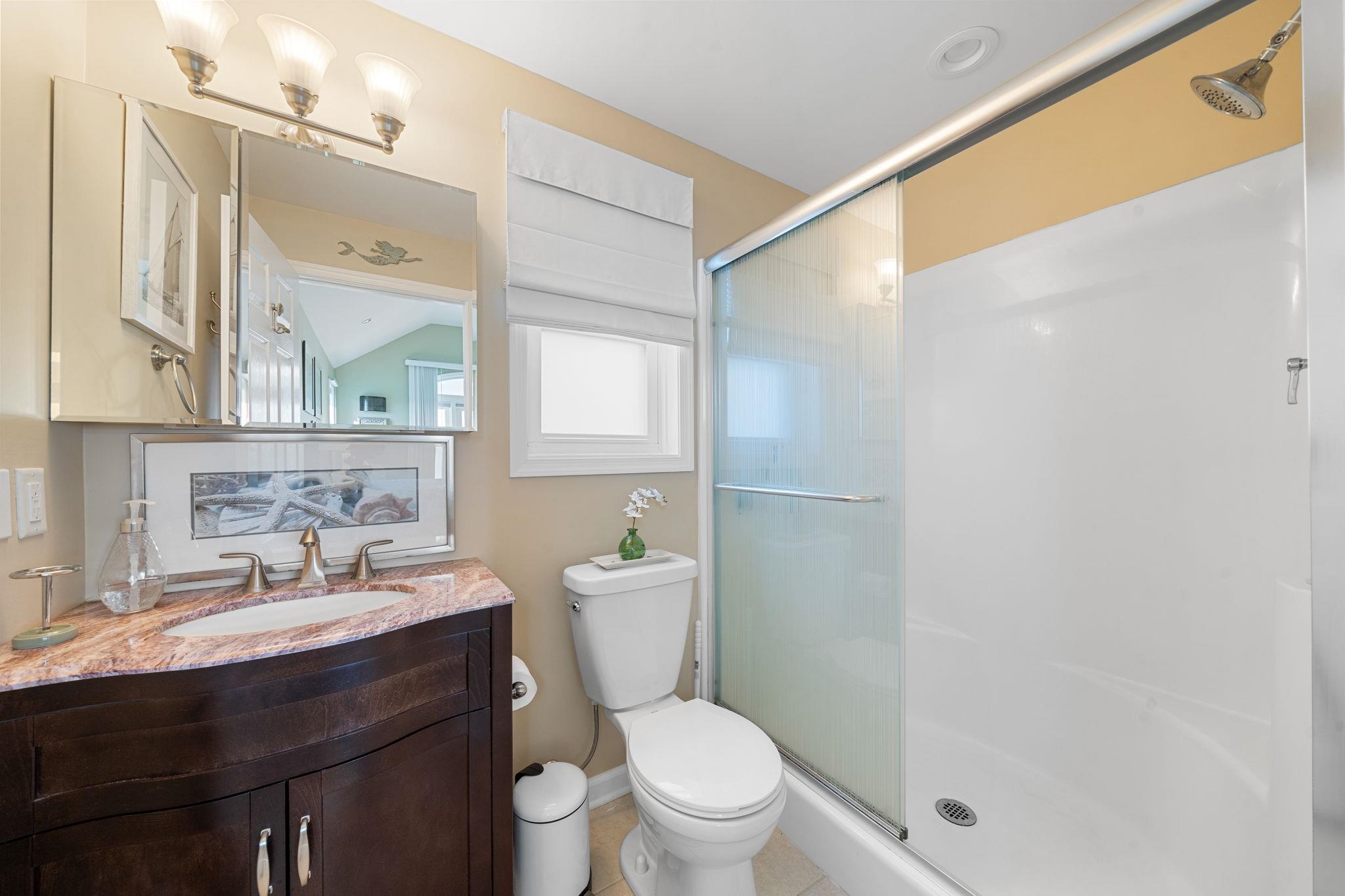 704 South Commonwealth Avenue Strathmere, NJ 08248 - Photo 43 of 50 a bathroom with a sink a toilet a mirror and a shower