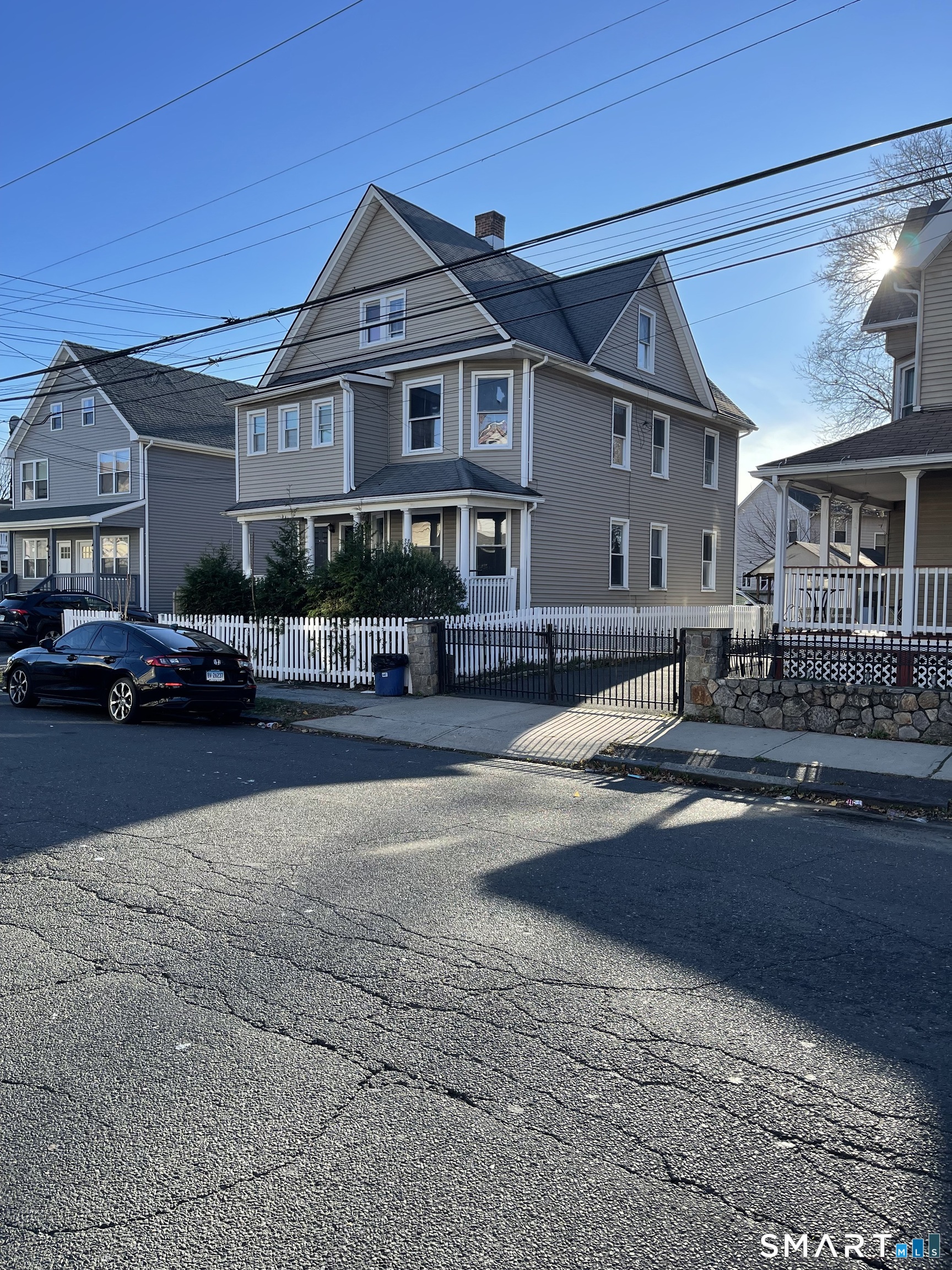 1199 Iranistan Avenue Bridgeport, CT 06605 - Photo 1 of 6 a front view of a house with cars parked on road