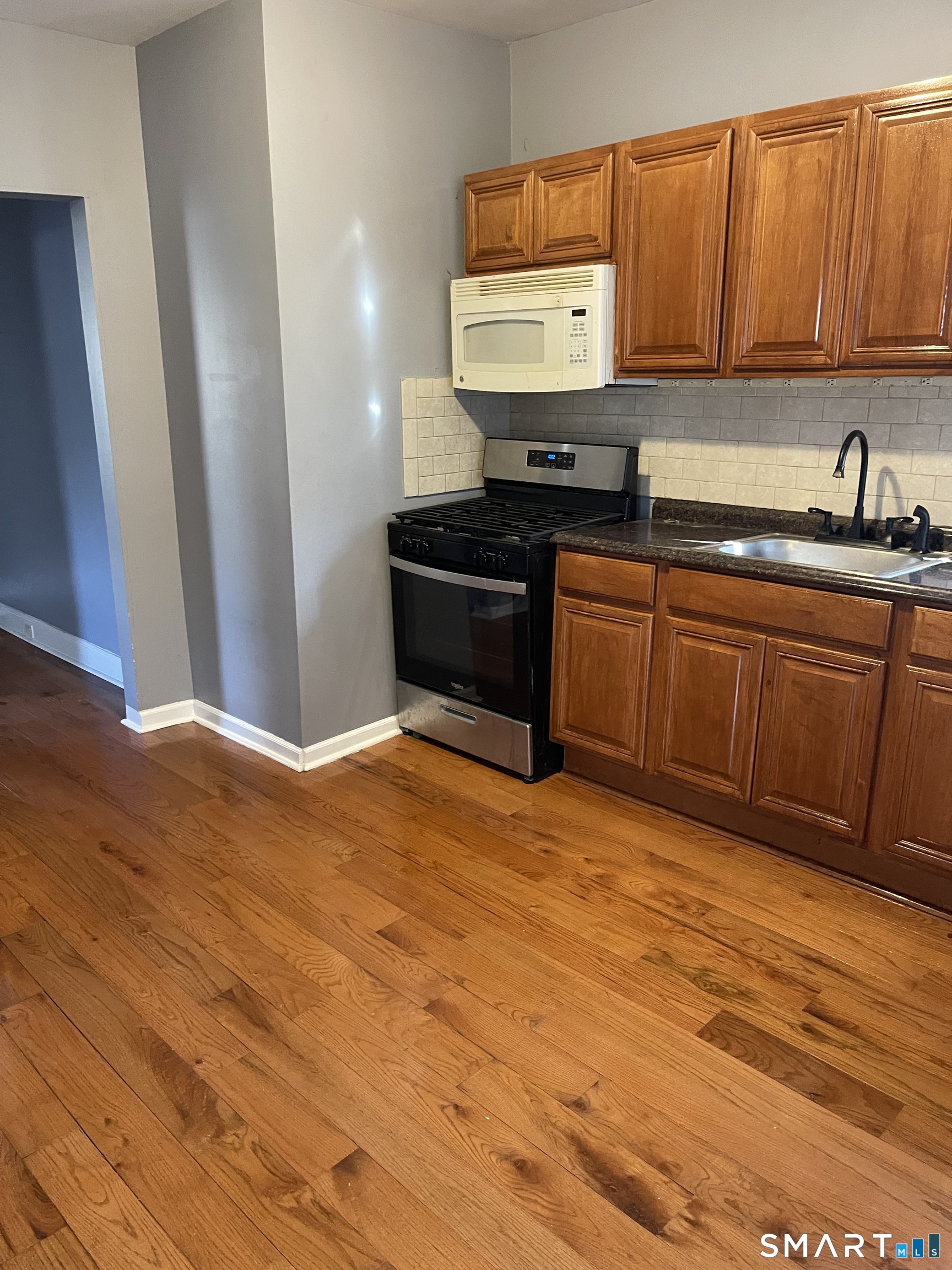 1199 Iranistan Avenue Bridgeport, CT 06605 - Photo 2 of 6 a kitchen with stainless steel appliances granite countertop a sink stove and cabinets