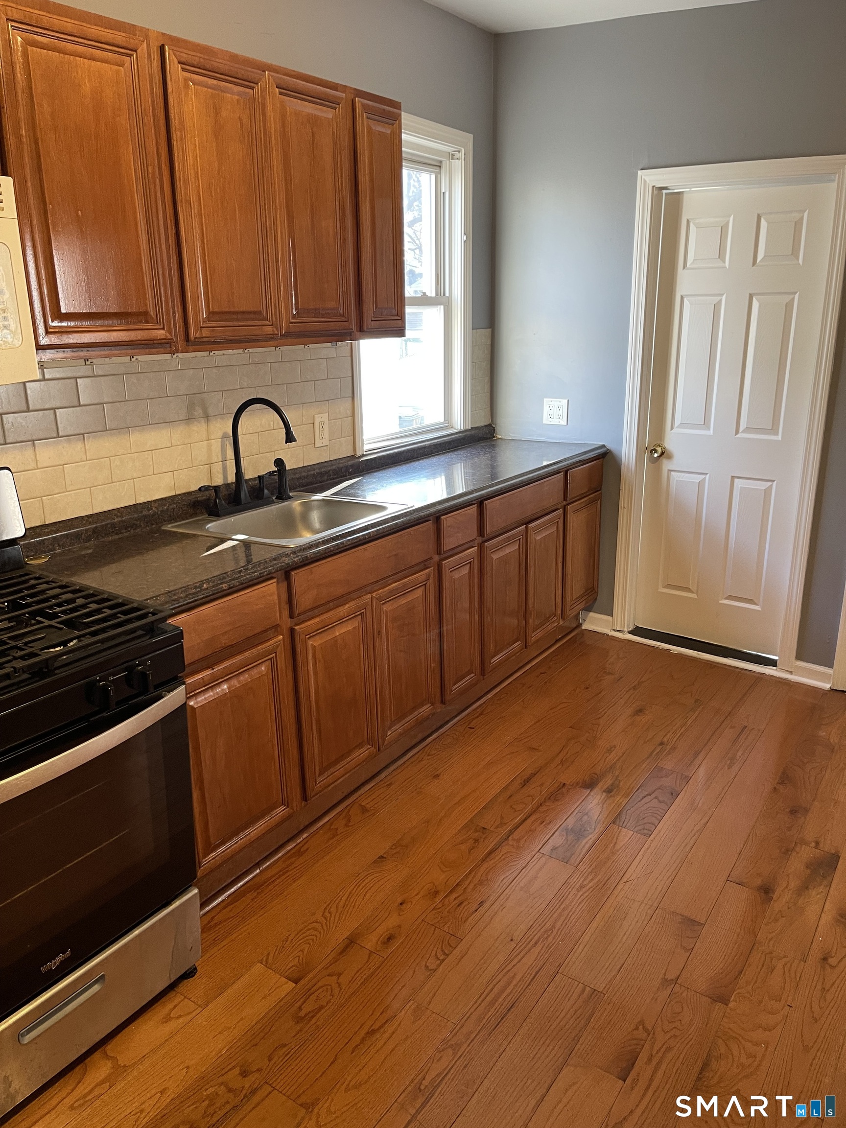 1199 Iranistan Avenue Bridgeport, CT 06605 - Photo 3 of 6 a kitchen with stainless steel appliances granite countertop a stove a sink and a microwave