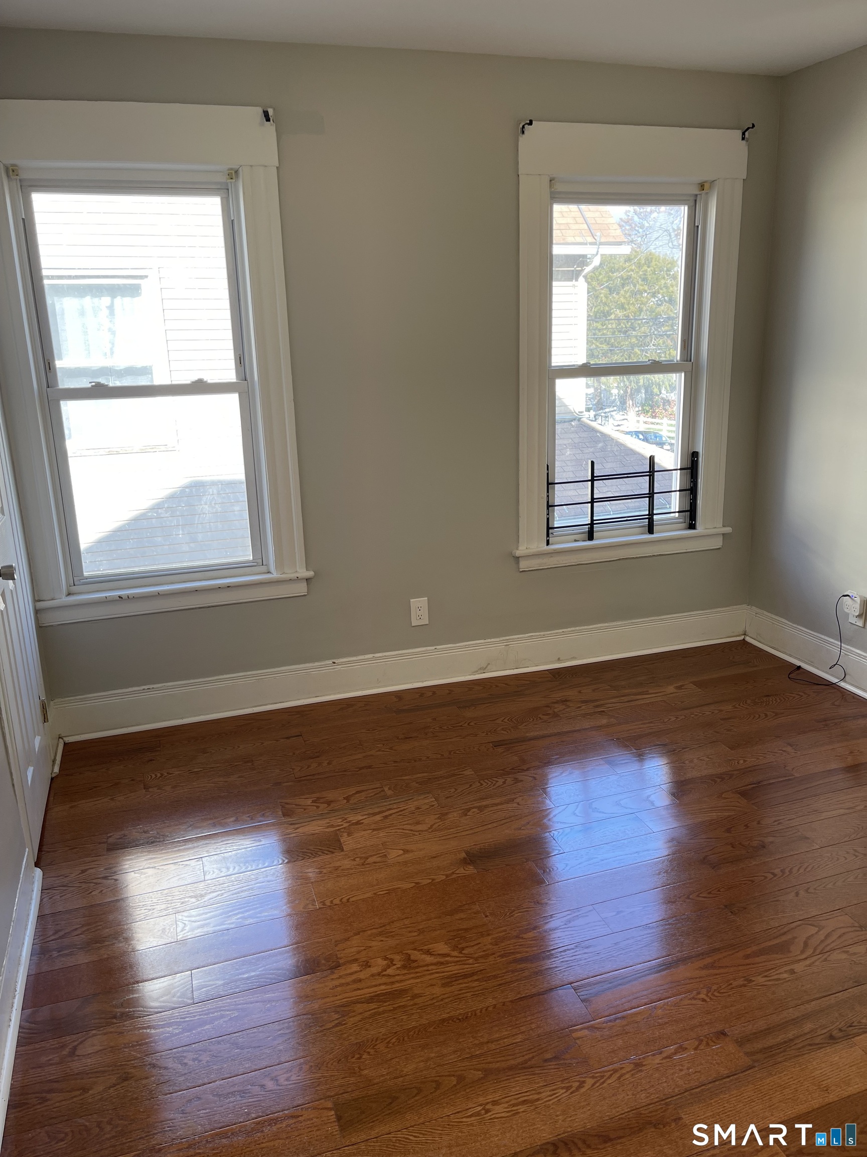 1199 Iranistan Avenue Bridgeport, CT 06605 - Photo 4 of 6 a view of an empty room with wooden floor and a window