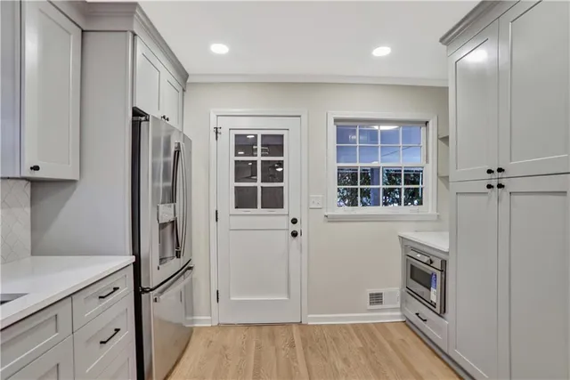 a kitchen with a refrigerator and more cabinets