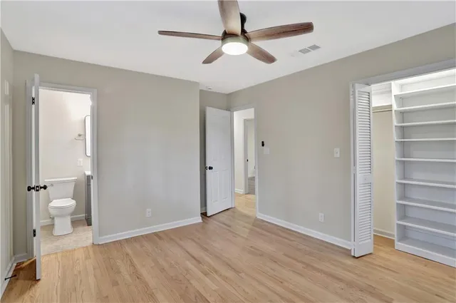 a view of a room with wooden floor and a ceiling fan