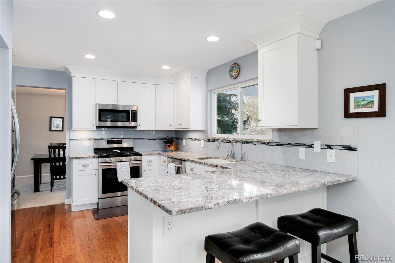 405 Northridge Road Highlands Ranch, CO 80126 - Photo 12 of 40 a kitchen with stainless steel appliances granite countertop a sink a stove and a refrigerator