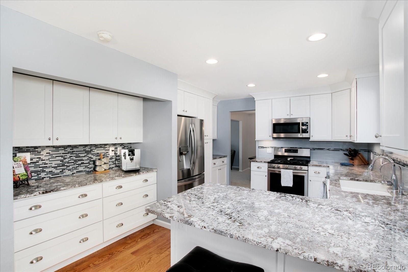 405 Northridge Road Highlands Ranch, CO 80126 - Photo 13 of 40 a kitchen with stainless steel appliances kitchen island granite countertop a sink stove and refrigerator