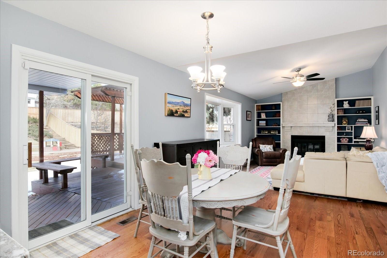405 Northridge Road Highlands Ranch, CO 80126 - Photo 14 of 40 a view of a dining room with furniture wooden floor a chandelier and a fireplace