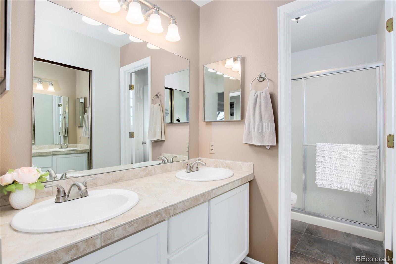 405 Northridge Road Highlands Ranch, CO 80126 - Photo 20 of 40 a bathroom with a granite countertop sink and a mirror
