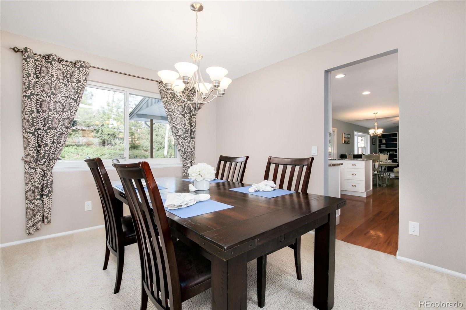 405 Northridge Road Highlands Ranch, CO 80126 - Photo 9 of 40 a view of a dining room with furniture a chandelier and wooden floor
