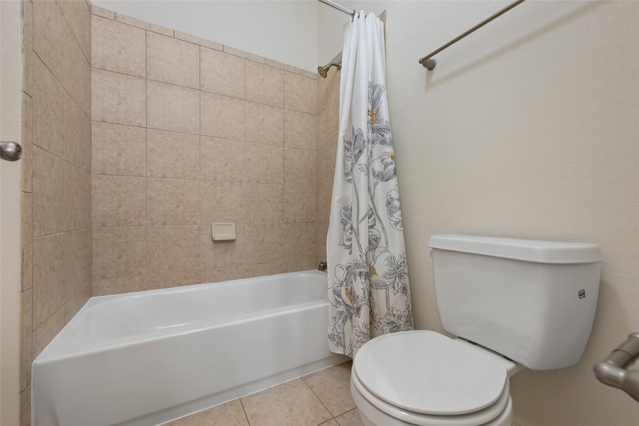 15205 Spillman Ranch Loop Austin, TX 78738 - Photo 34 of 40 A well-appointed bath features tile flooring and walls, alongside a tub and shower combination.