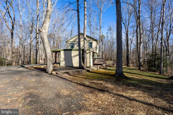 a front view of a house with a yard fire pit and large trees