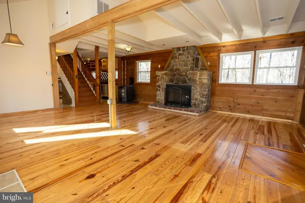 a view of a livingroom with wooden floor and a fireplace
