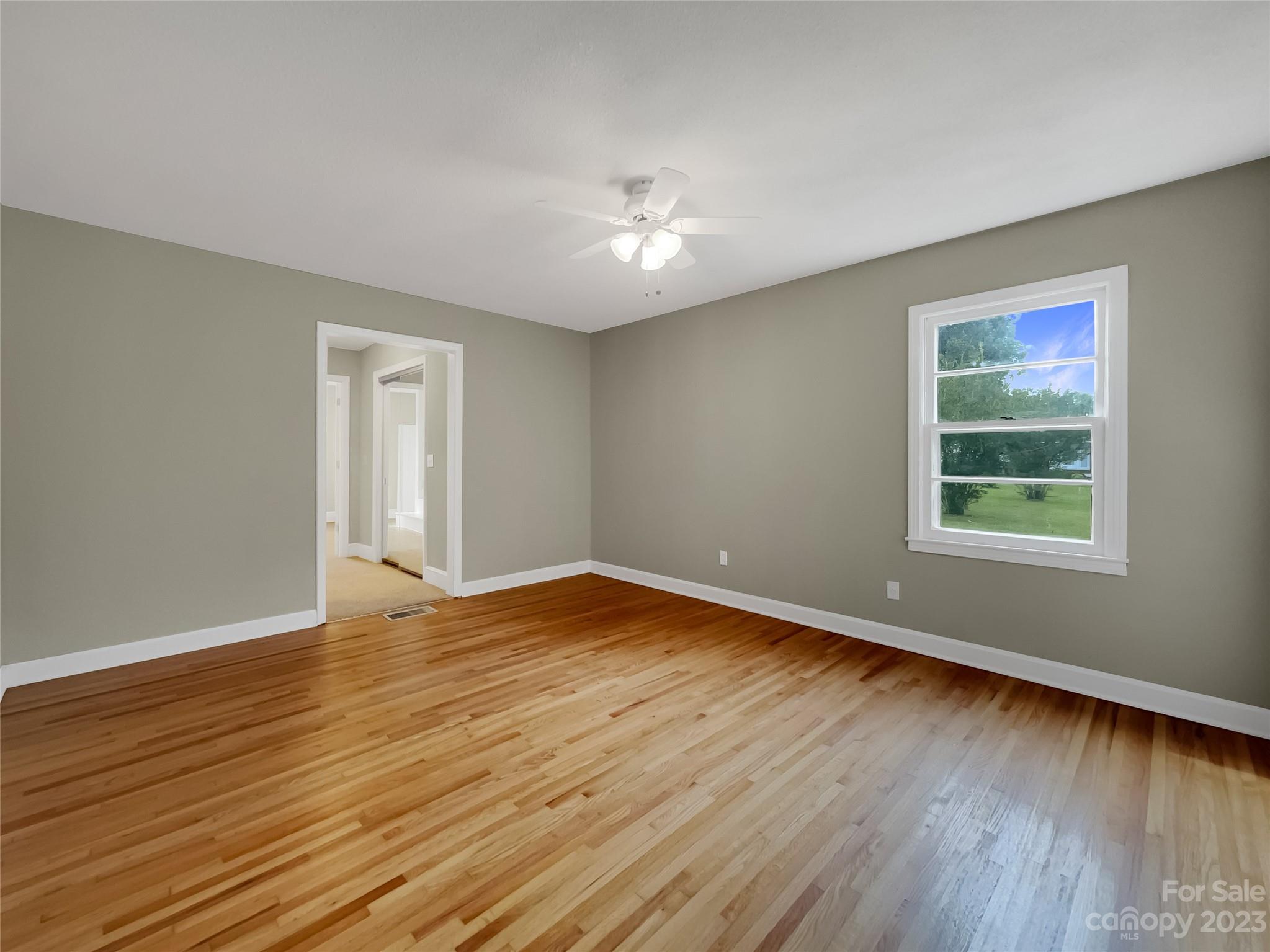 4719 Pleasant Grove Road Waxhaw, NC 28173 - Photo 5 of 24 a view of an empty room with wooden floor and a window