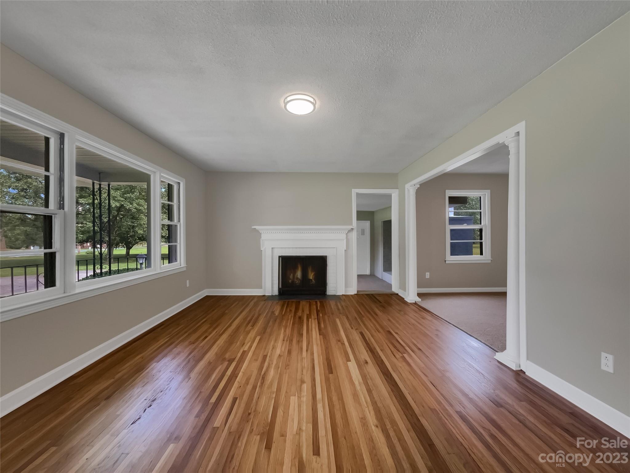 4719 Pleasant Grove Road Waxhaw, NC 28173 - Photo 8 of 24 a view of an empty room with wooden floor fireplace and a window
