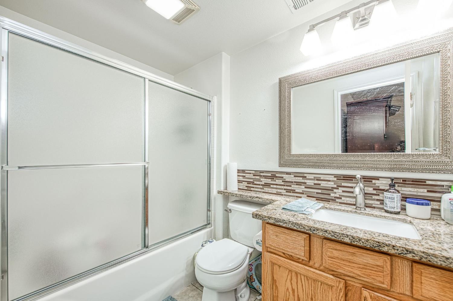 1002 Sequoia Court Fowler, CA 93625 - Photo 42 of 54 a bathroom with a granite countertop sink mirror vanity and toilet