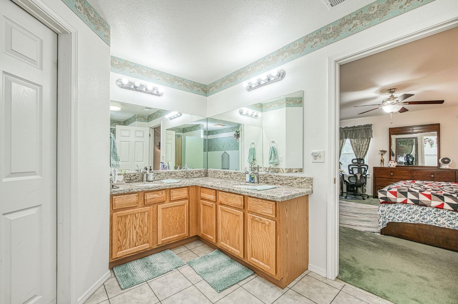 1002 Sequoia Court Fowler, CA 93625 - Photo 54 of 54 a spacious bathroom with a granite countertop sink and a mirror