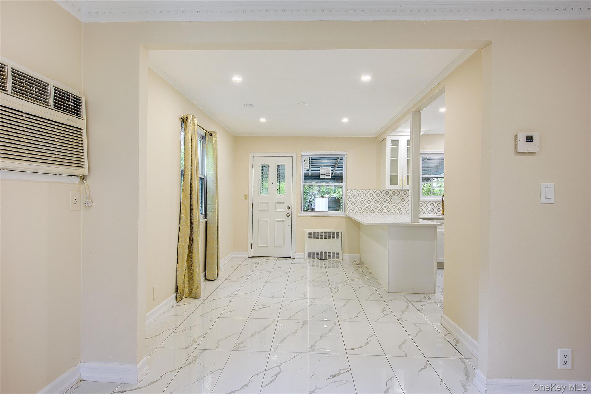 164-38 76th Road Queens, NY 11366 - Photo 7 of 44 a view of a big room with windows and entryway