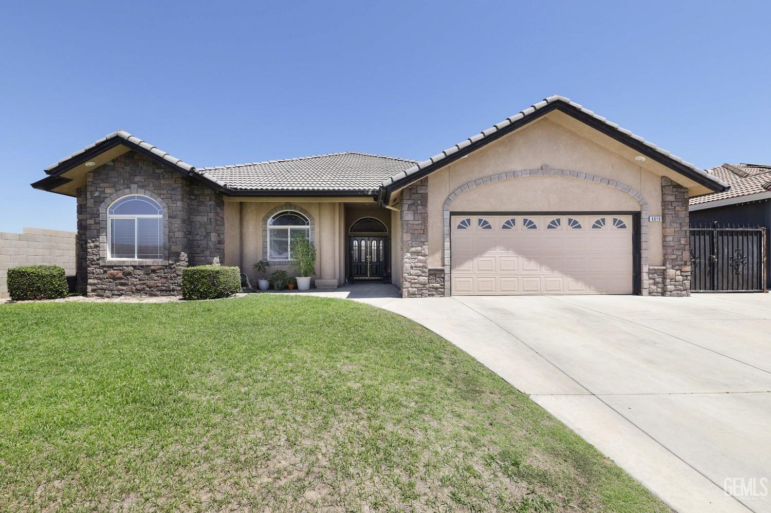 Undisclosed Address Bakersfield, CA 93313 - Photo 1 of 29 a front view of a house with a yard and garage
