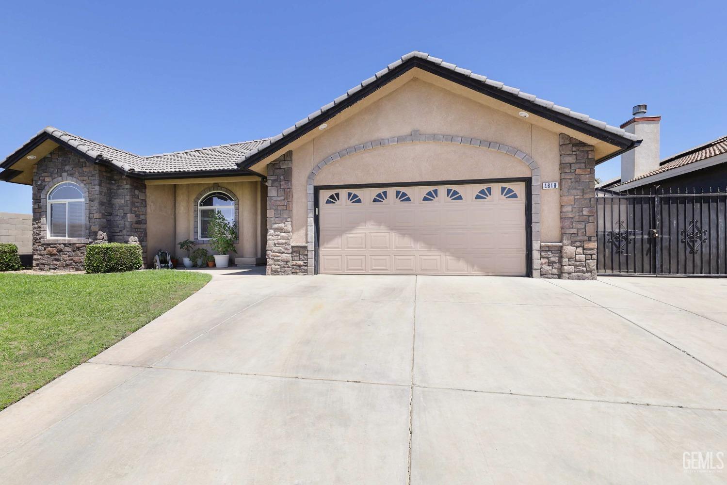 Undisclosed Address Bakersfield, CA 93313 - Photo 2 of 29 a front view of a house with a yard and garage