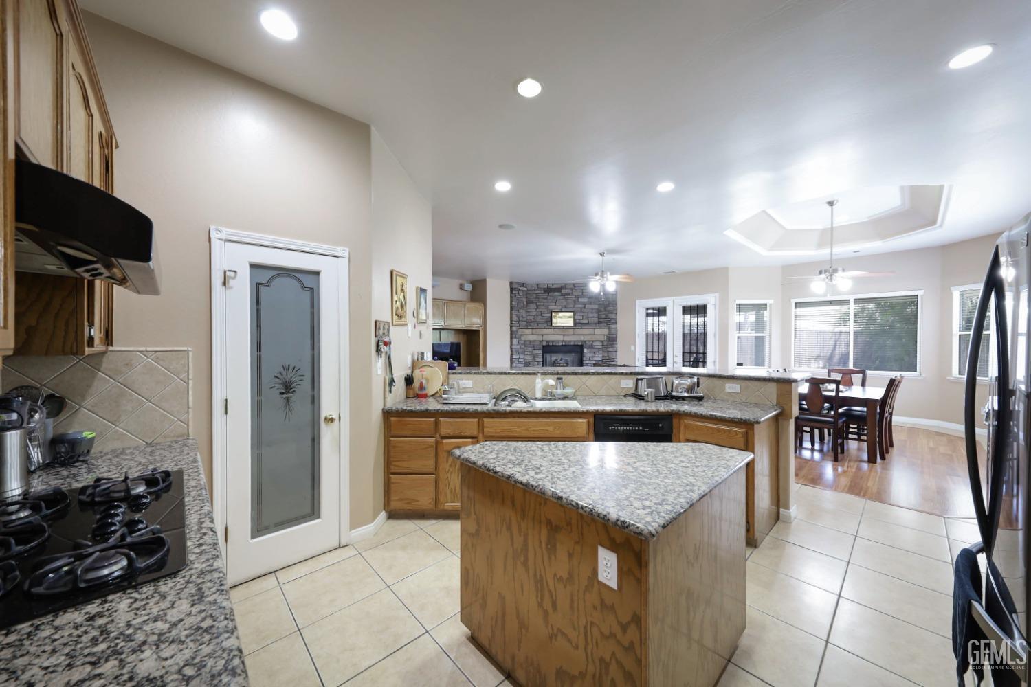 Undisclosed Address Bakersfield, CA 93313 - Photo 21 of 29 a kitchen with a stove a refrigerator and a dining table