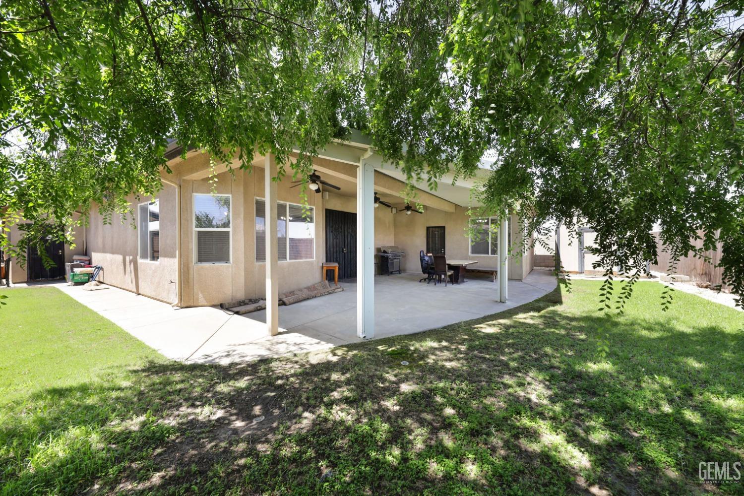 Undisclosed Address Bakersfield, CA 93313 - Photo 24 of 29 a view of a white house in front of a yard with plants and large trees