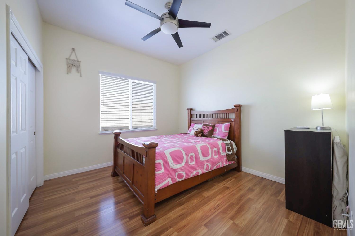 Undisclosed Address Bakersfield, CA 93313 - Photo 9 of 29 a bedroom with a bed and wooden floor