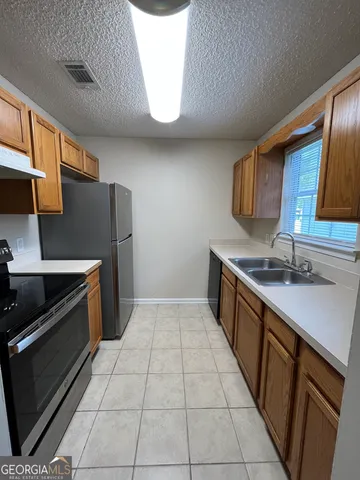 a kitchen with stainless steel appliances a sink stove and cabinets