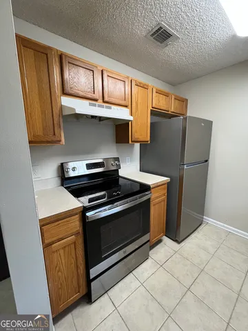 a kitchen with stainless steel appliances granite countertop a stove a refrigerator and a microwave